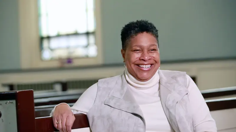 Woman sitting in church pew smiling